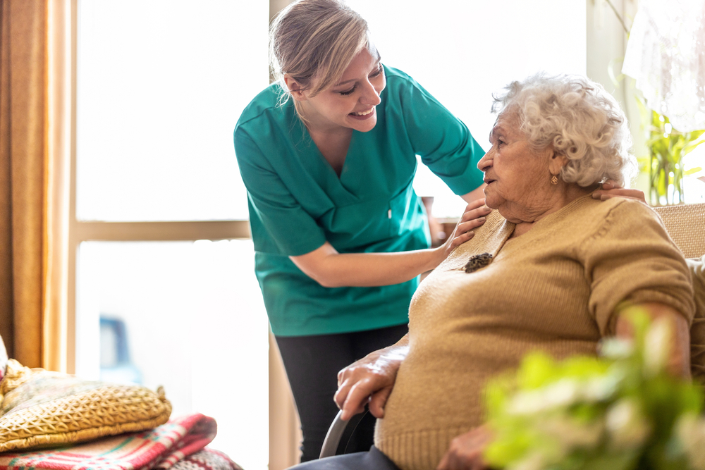 social care staff helping elderly lady